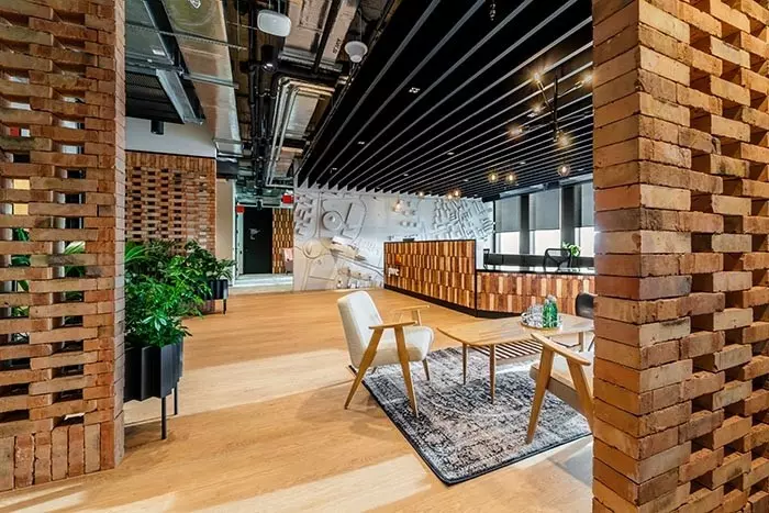 Biuro PwC SDC w Katowicach projektu The Design Group – strefa recepcji, w której wykorzystano cegłę z rozbiórki